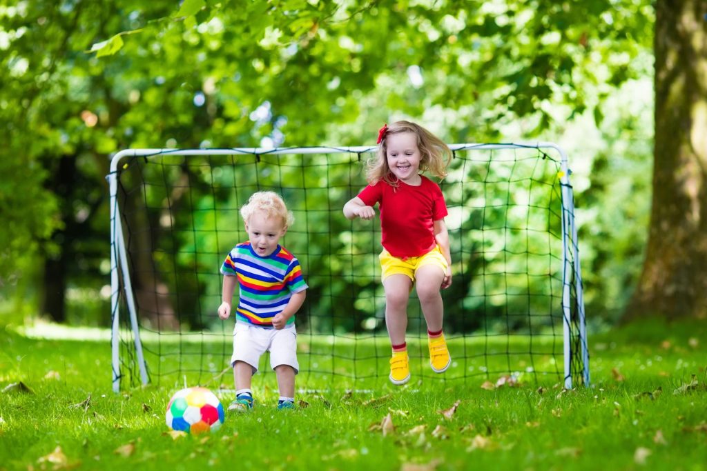 2 children playing football together